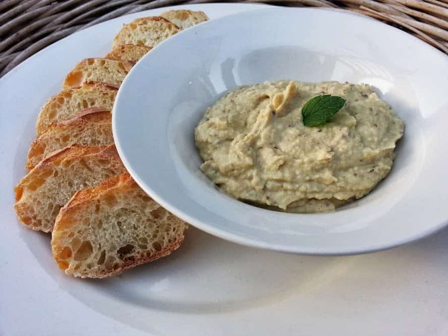 Roasted Garlic Artichoke Dip served in a plate with bread