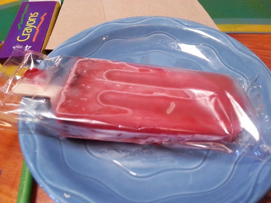 A popsicle fruit bar on a blue plate.