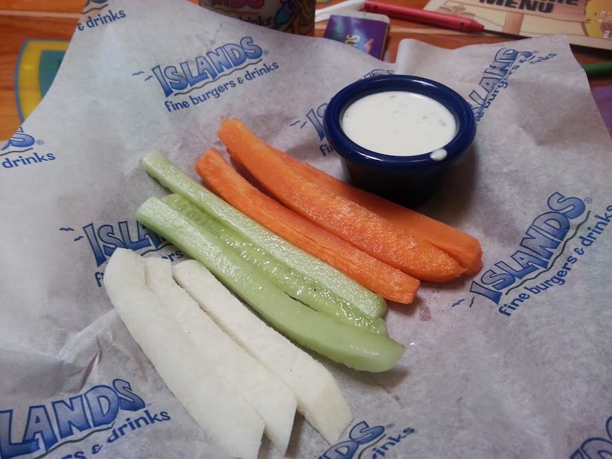 Carrot sticks, jicama, and celery next to ranch dressing on a napkin at Islands.
