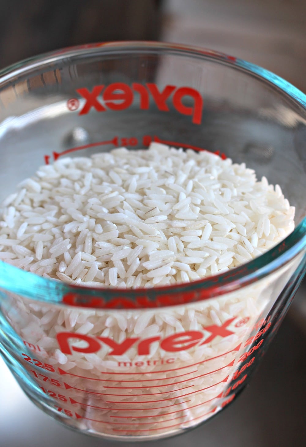 A measuring cup with white rice inside. 