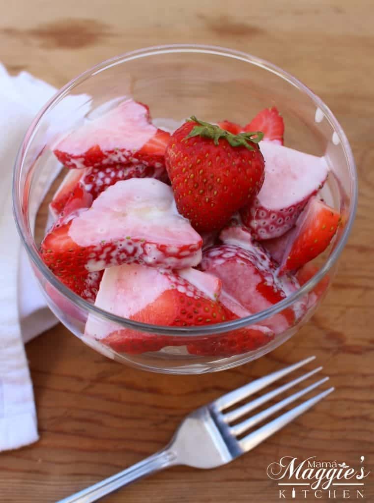 Fresas con Crema, or Mexican Strawberries and Cream, in a glass container and fork.