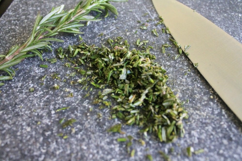 Chopped Rosemary next to a Knife