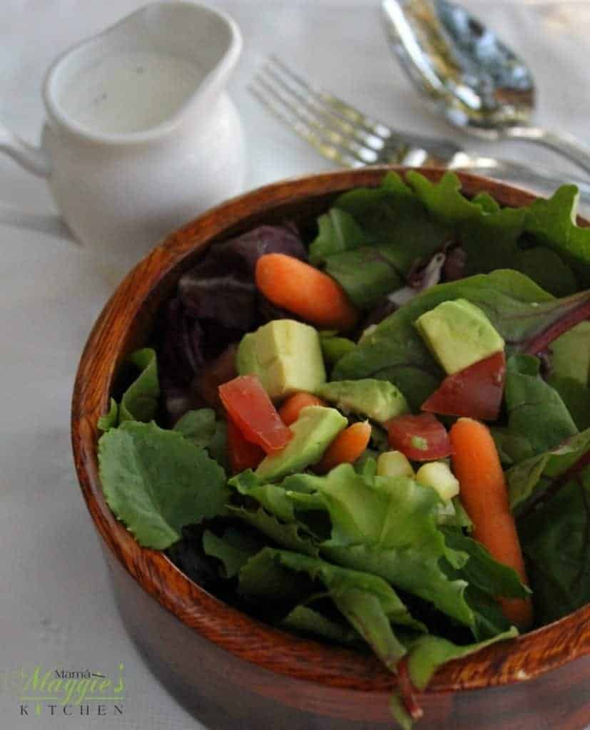 Lemon Parmesan Dressing next to a salad with carrots and avocado