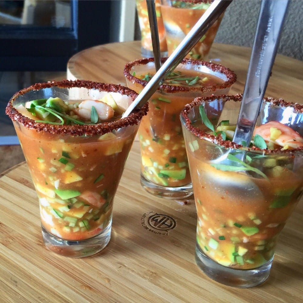 Shrimp Michelada served in small glass cups with spoons.