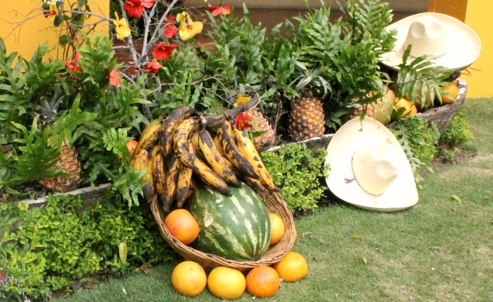Outside of El Eden, pineapples, charros hats and a basket of fruit with bananas, oranges and watermelon
