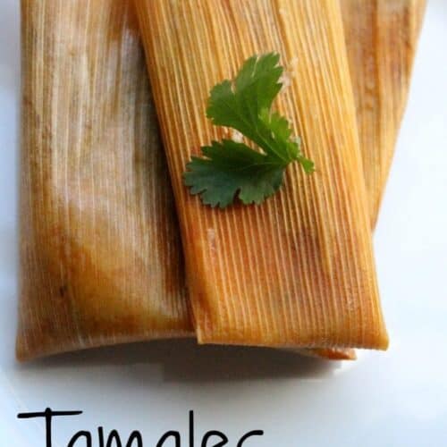 Tamales Rajas con Queso, or Jalapeño and Cheese Tamales on a white plate topped with a green cilantro leaf.