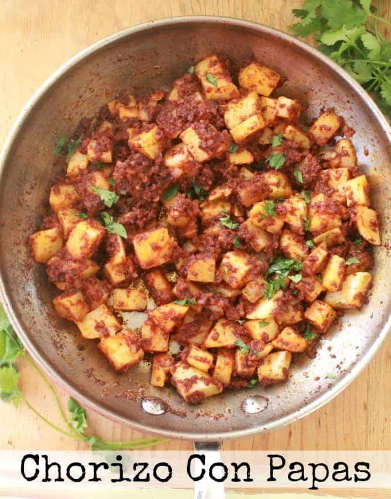 Chorizo Con Papas in a skillet and topped with chopped cilantro.