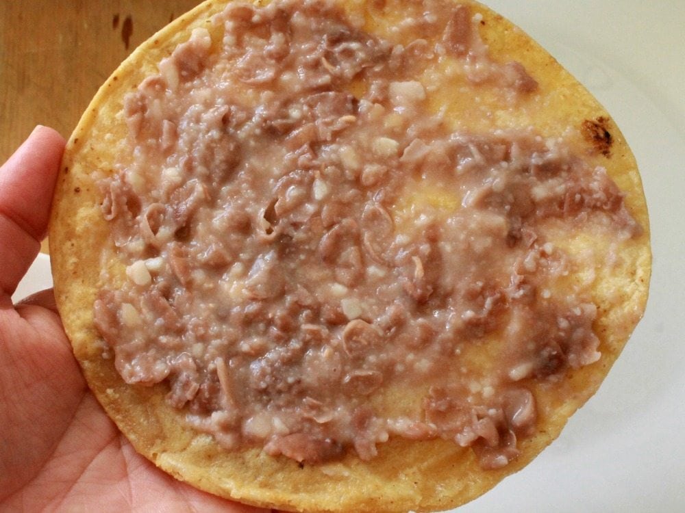 A thin layer of refried beans on a tortilla.