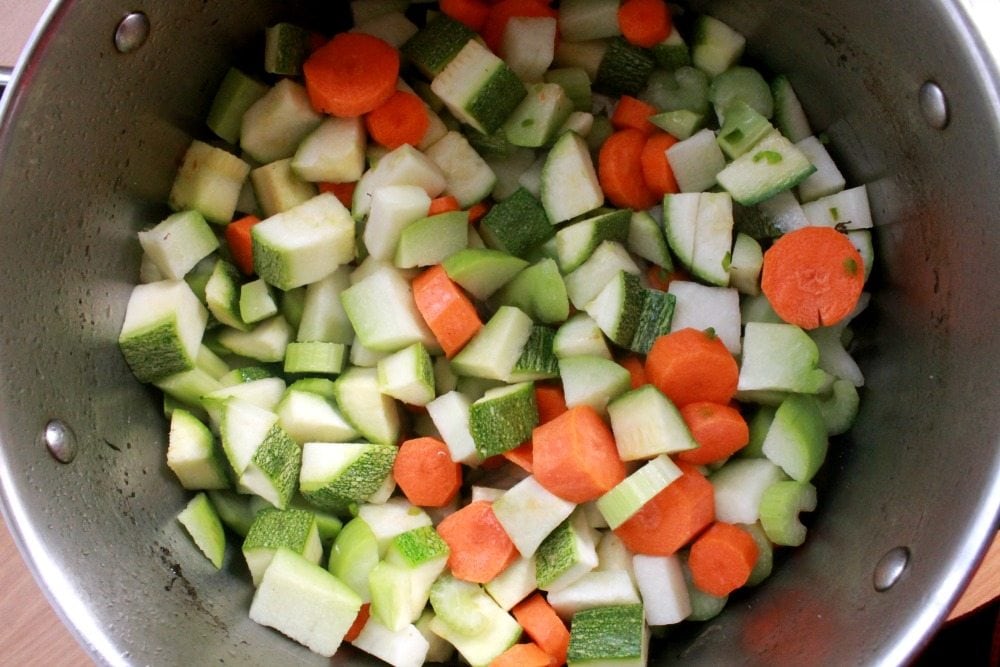 A pot with vegetables cooking inside.