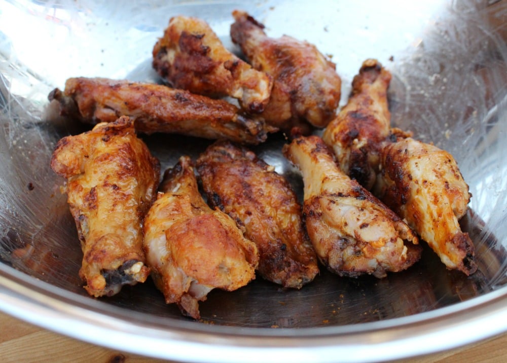 Baked chicken wings in a metal bowl.