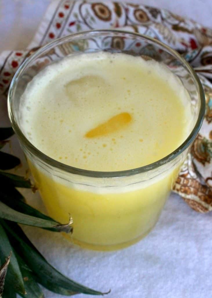 Pineapple Agua Fresca, or Agua de Piña, in a glass cup with ice in the center.