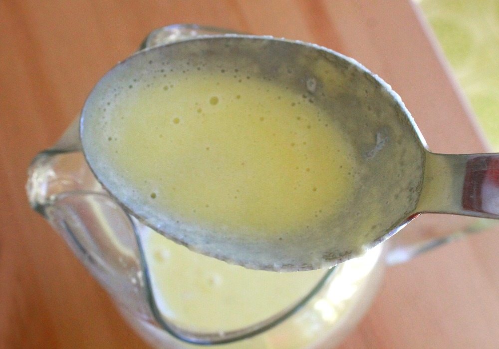 A cooking spoon holding the blended pineapple mixture.
