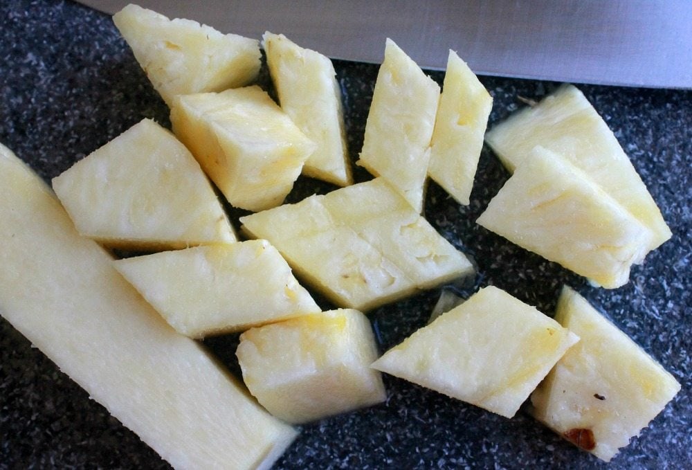 Diced pineapple on a cutting board.