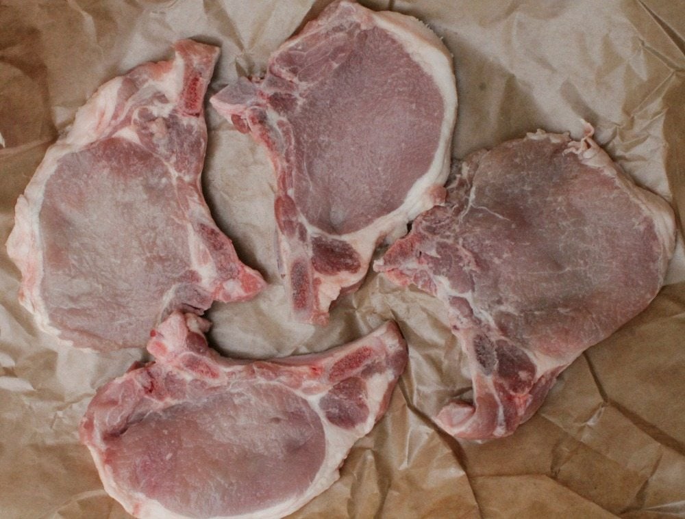 Raw pork Chops on a brown wrapping paper.