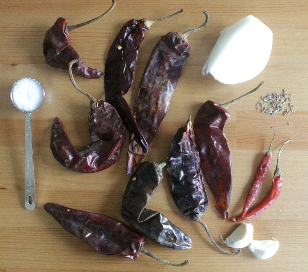 The ingredients for the red chile sauce spread out on a wooden table.