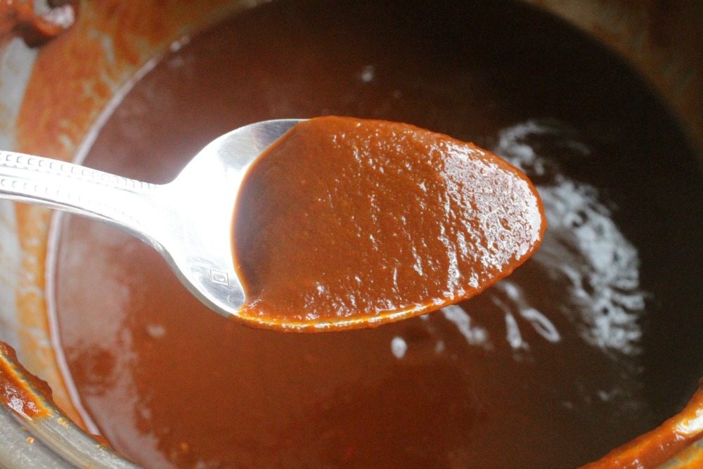 A spoonful of chile colorado sauce above the blender.