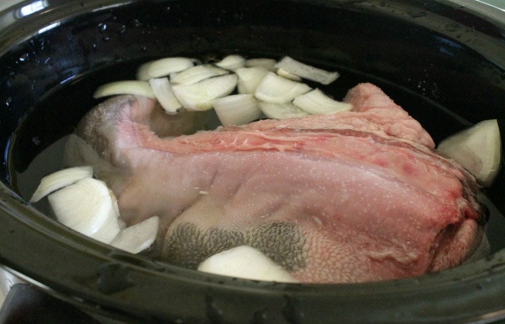 Beef tongue in the slow cooker and covered with water.