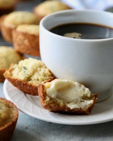 Zucchini Lemon Jalapeño Muffins served next to a cup of coffee.