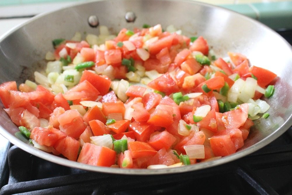 Diced tomatoes, jalapeno, and onion in a skillet