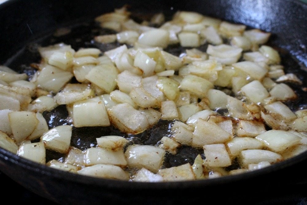 Diced onion cooking in cast iron skillet