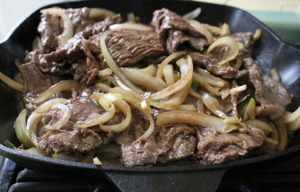 Cooked beef and onion in cast iron skillet.
