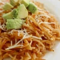 Fideo Seco, or Mexican Pasta, topped with diced avocado and shredded cheese