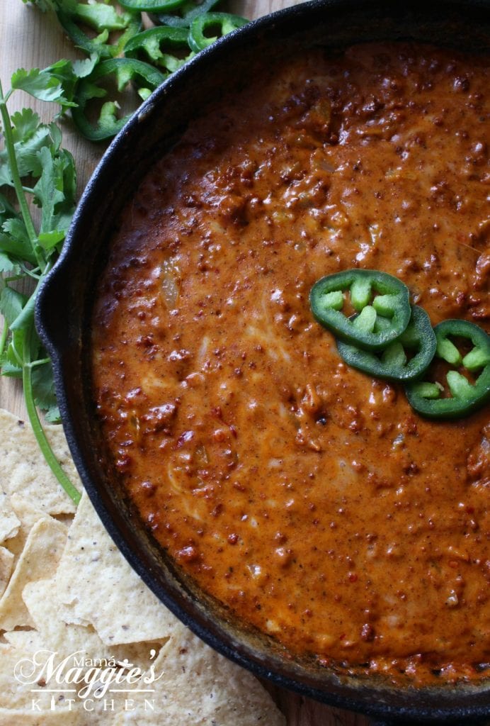 Queso Fundido with Chorizo topped with jalapeno slices and surrounded by cilantro and tortilla chips