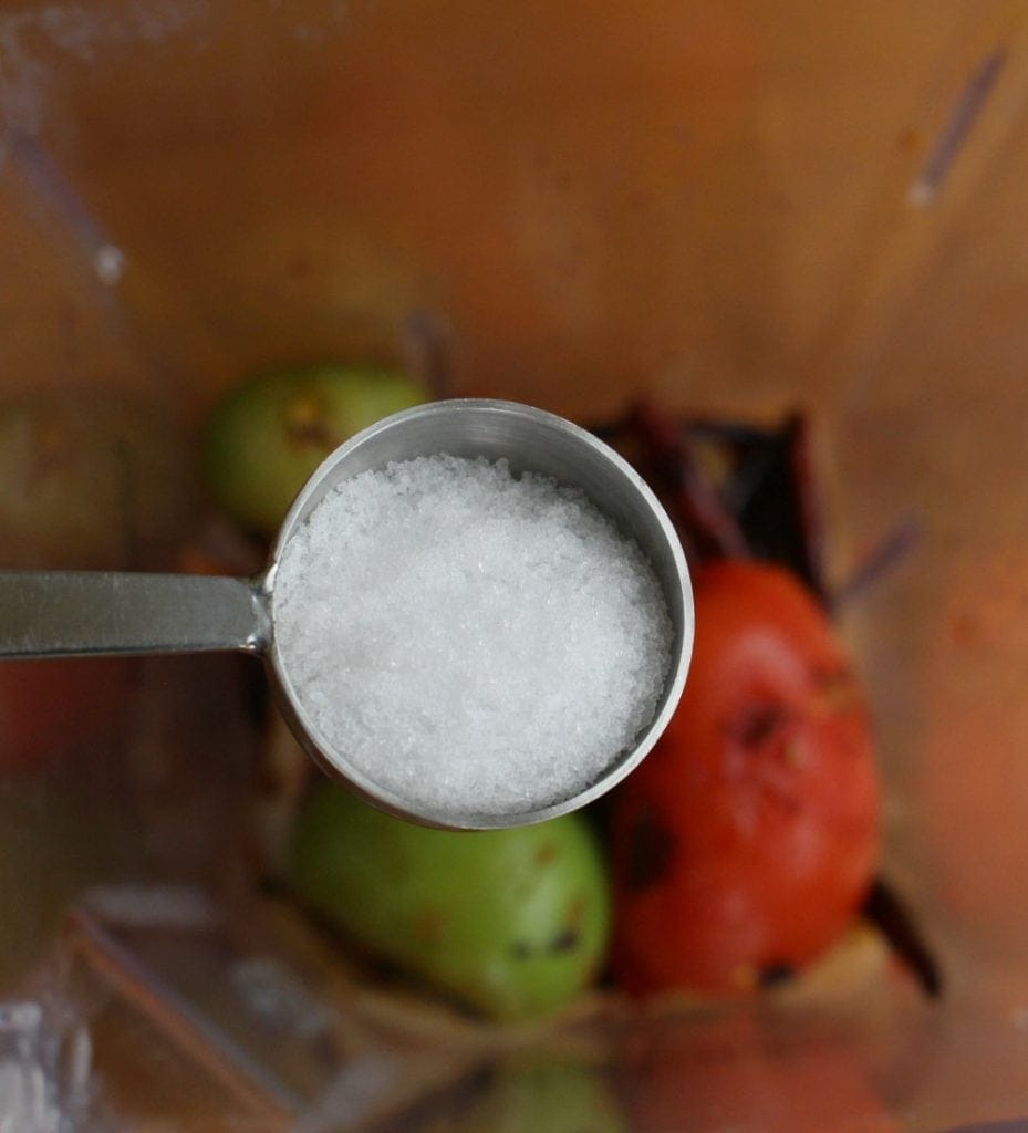 Tablespoon of salt over the ingredients inside a blender.