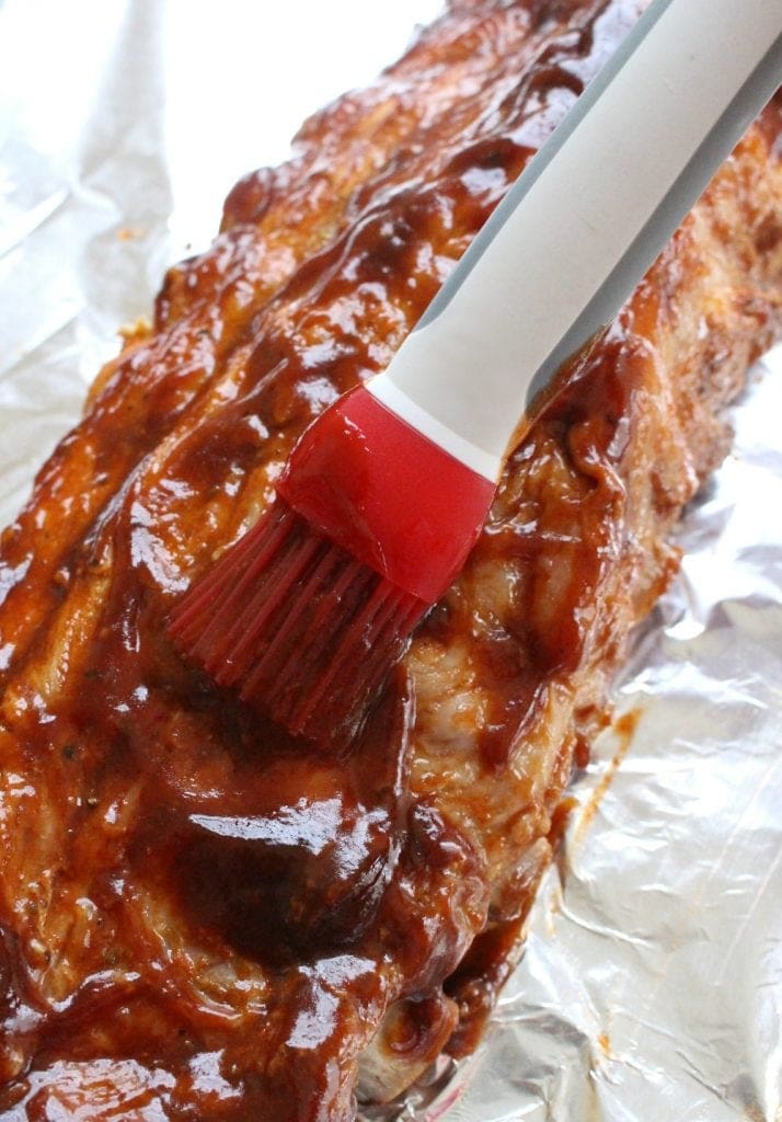 Brushing BBQ sauce on ribs