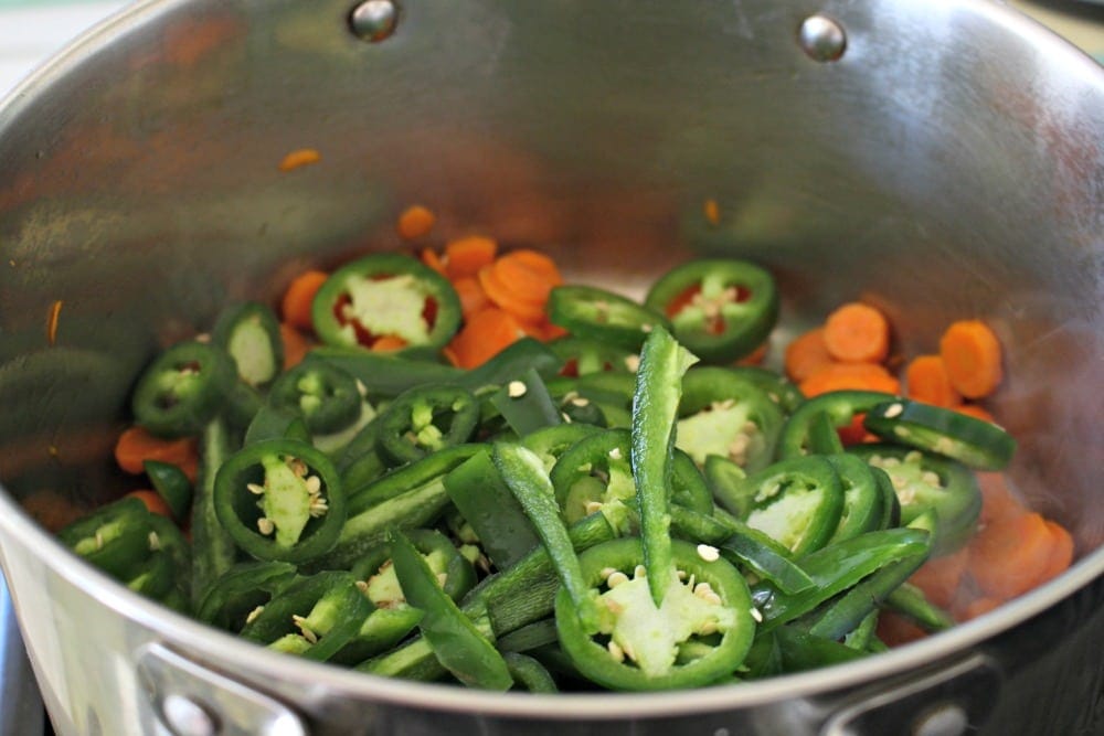 Jalapenos and carrots cooking in stockpot.
