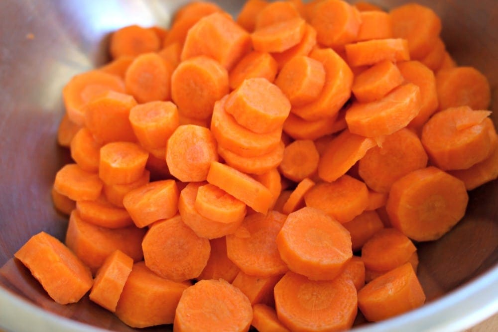 Sliced carrots on a metal bowl.