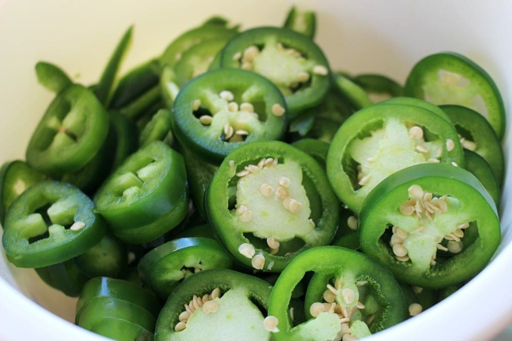 Fresh jalapenos in a bowl and sliced.