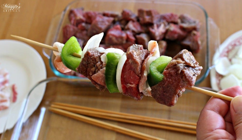 Hand holding uncooked Mexican Beef Skewers