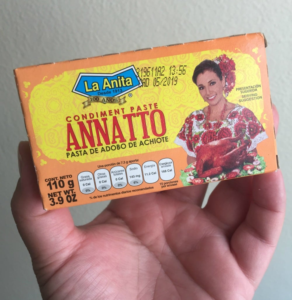 hand holding box of achiote paste