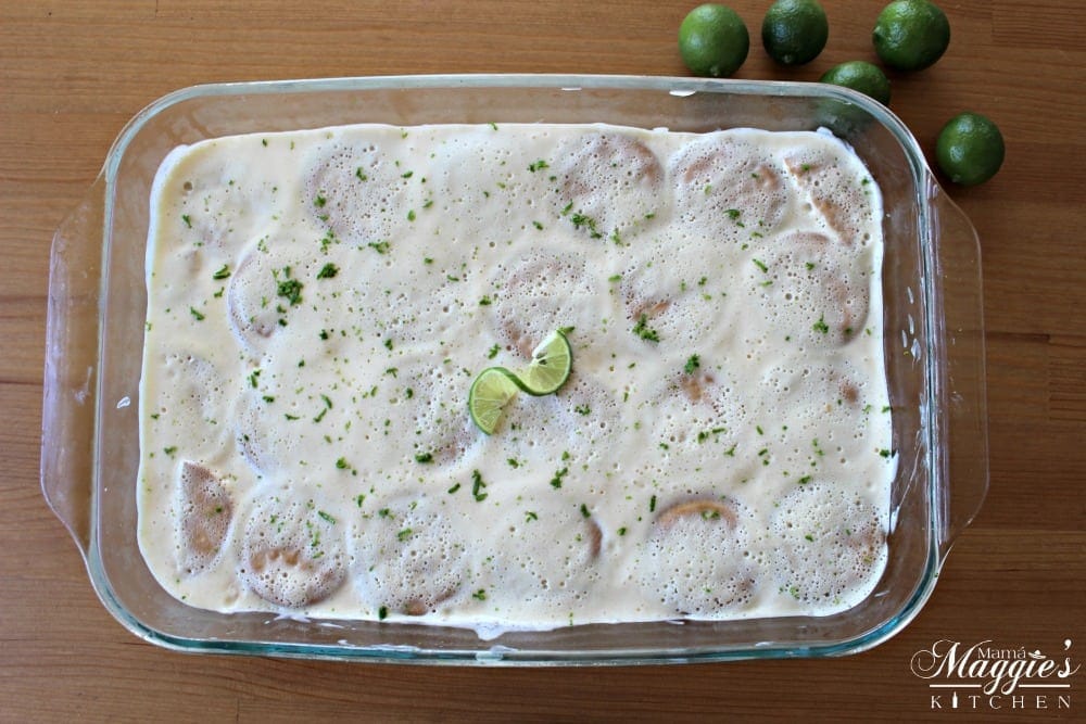 Carlota de Limon in baking dish topped with lime zest and lime slices.