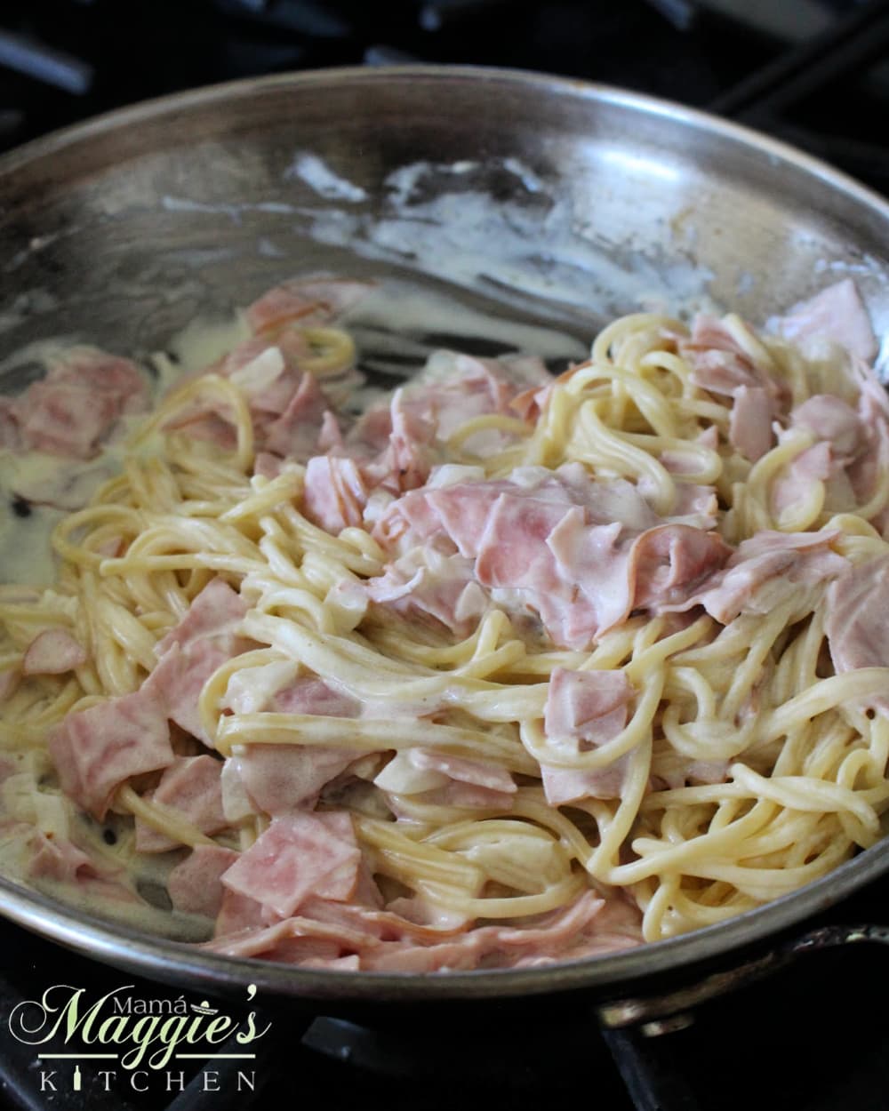 Cooked spaghetti added to the skillet and mixed with the ham and cream sauce.