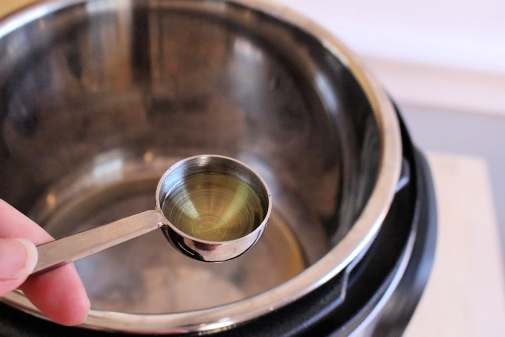 Tablespoon of olive oil over an instant pot. 