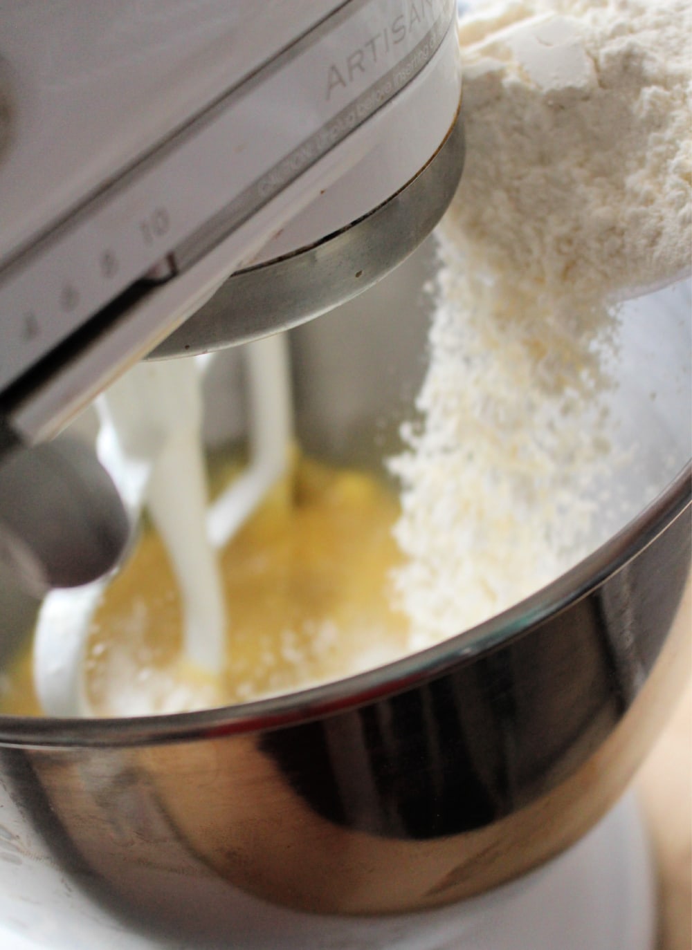 Flour pouring into a Kitchen Aid mixer. 