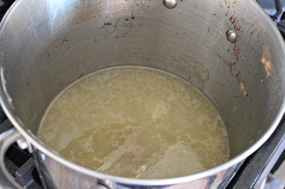 Chicken broth in a metal stock pot.