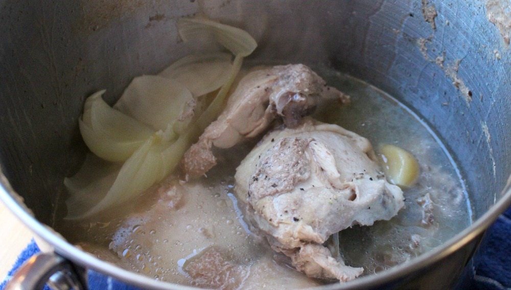 Cooked chicken and chicken broth in a stock pot.