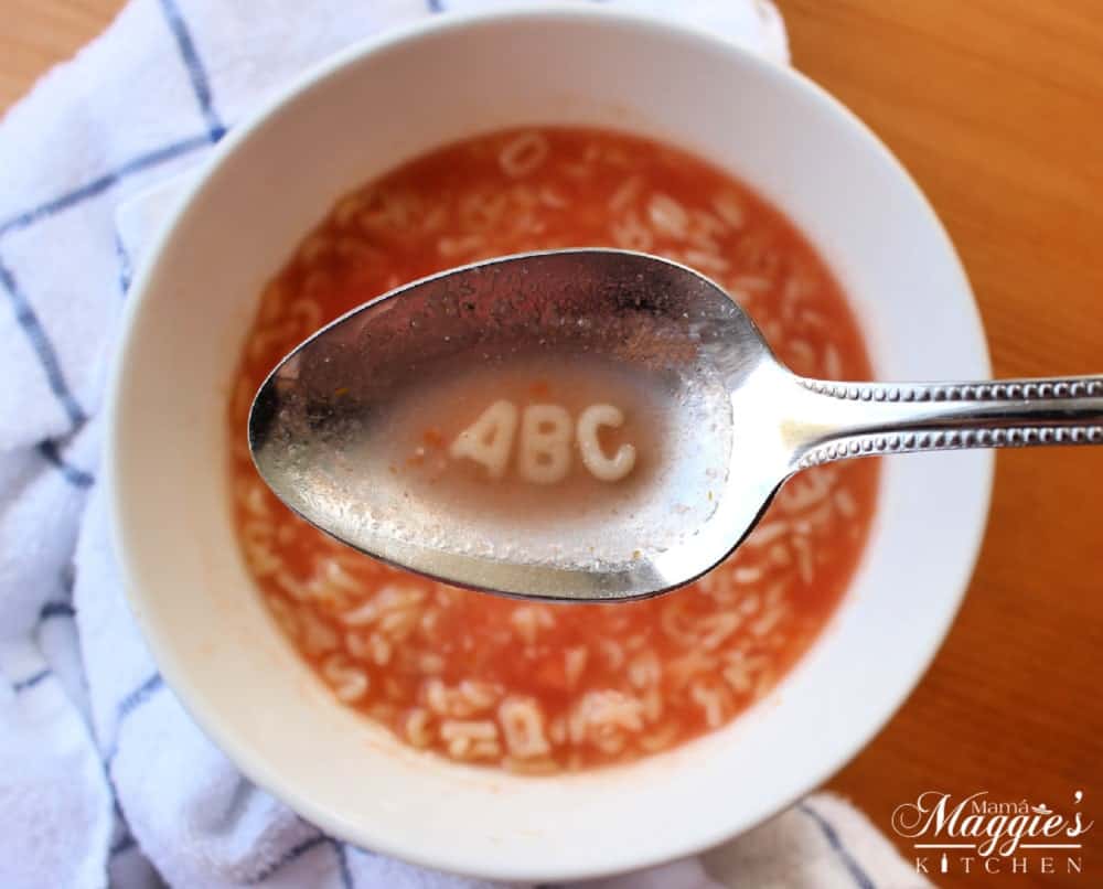 Spoon holding ABC over a bowl full of Sopa de Letras, or Mexican Alphabet Soup.