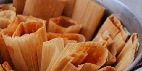 Pot of pork tamales with the open side up.