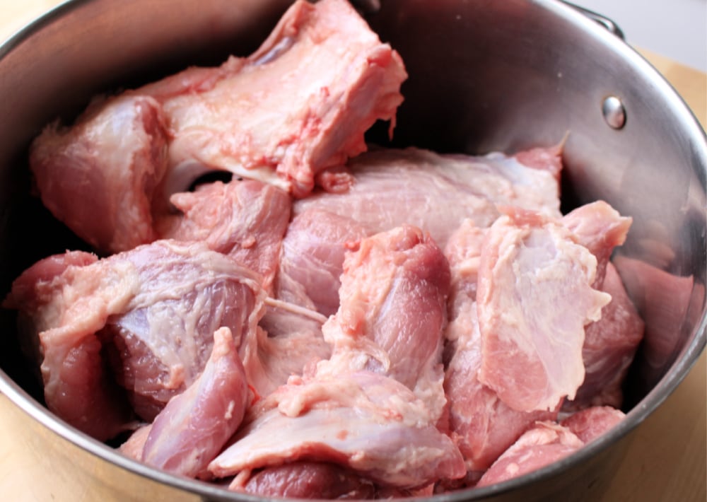 Raw pork pieces in a large stock pot. 