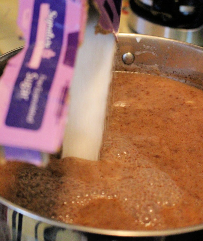 Box of sugar pouring into the champurrado pot. 