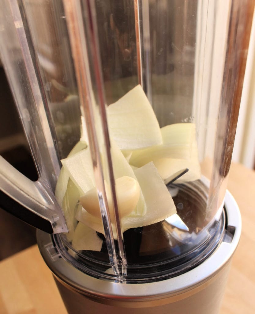 Chopped onion and garlic cloves in a blender. 