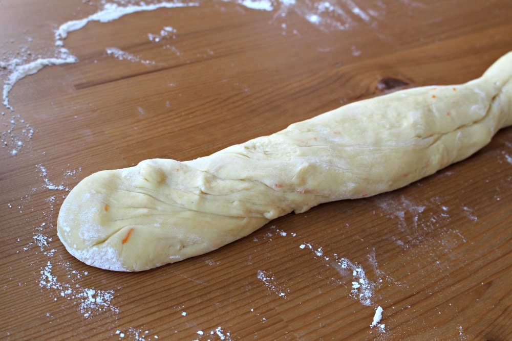 Thin piece of dough that has been rolled out on a wooden surface.
