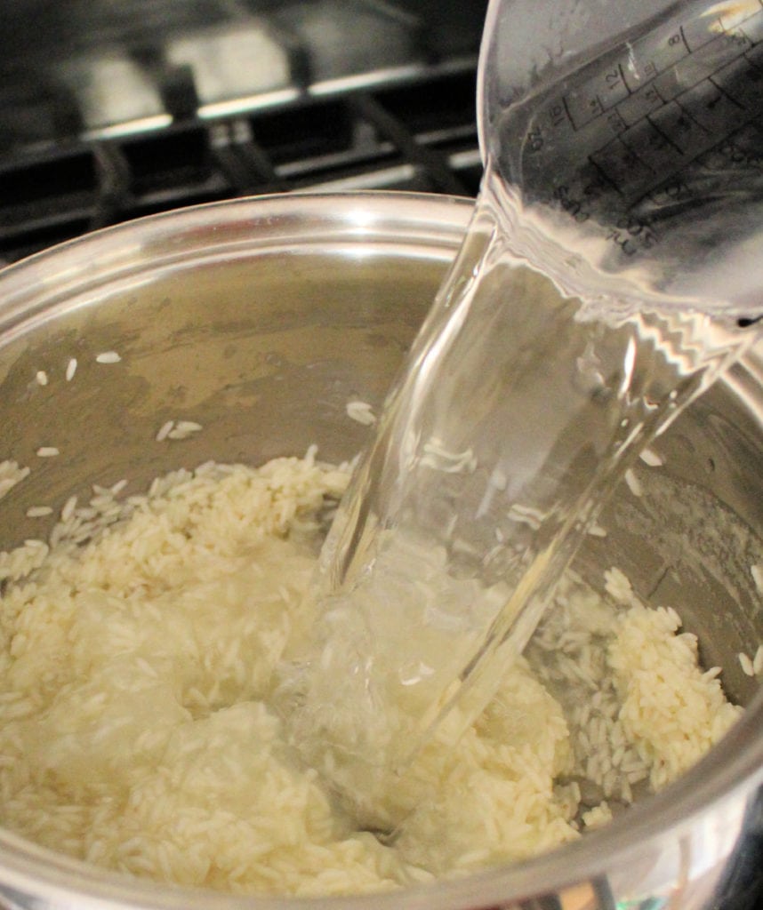 Water pouring into the stock pot with rice.