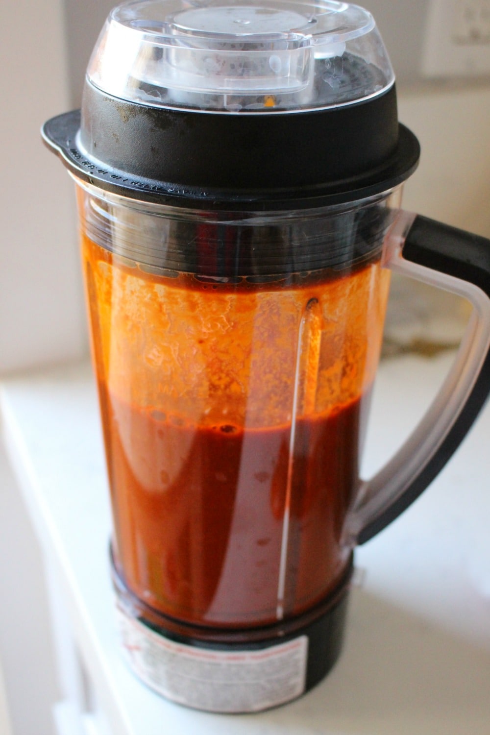 A blender with pork red sauce for tamales. 