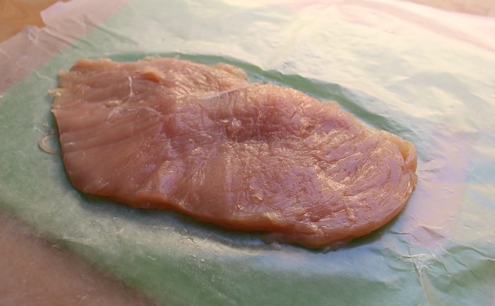 A thin slice of chicken on wax paper.