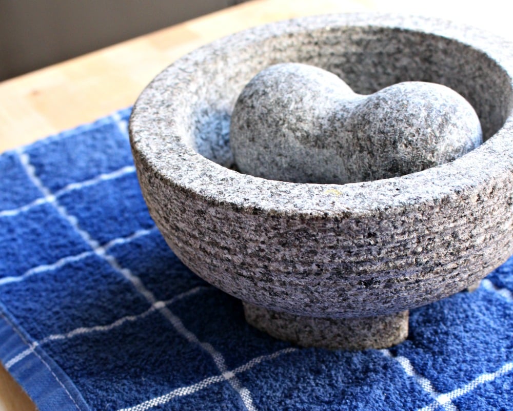 Molcajete on a blue towel and wood surface.